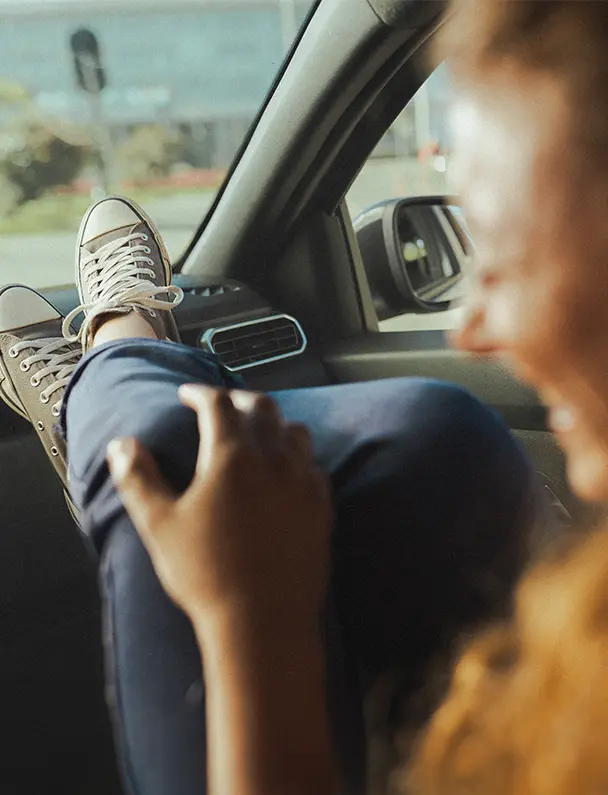 pessoa dirigindo um carro e sorrindo